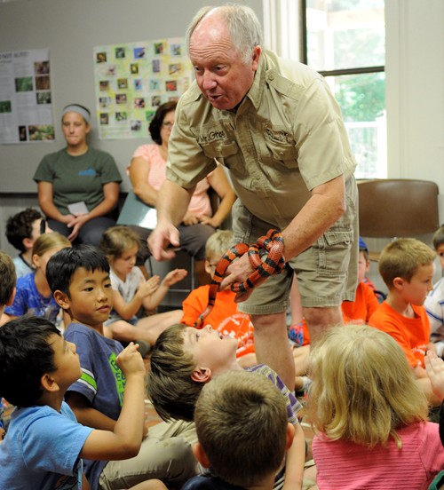 Greer talks to a group of students about the milk snake and allows them to feel the texture of the snake’s skin.
